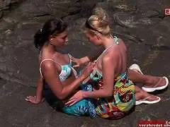 Zwei Frauen in einem gelben Strandbuggy mit Meerblick, eine lehnt sich zur anderen hinüber