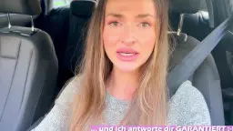 Sexy-Lexxy mit langen blonden Haaren sitzt angeschnallt auf dem Fahrersitz und blickt erregt in die Kamera